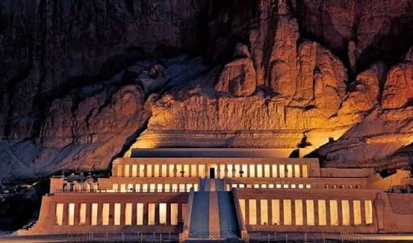 Temple of Hatshepsut lit up at night against the cliffs
