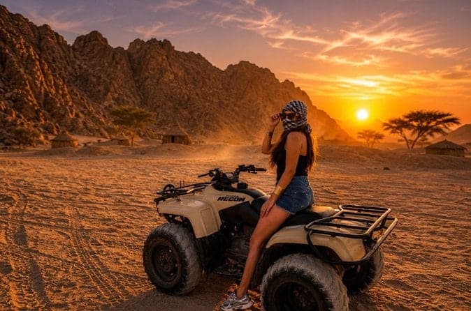 Quad bike Marsa Alam: rider resting on her quad at sunset below rocky desert mountains