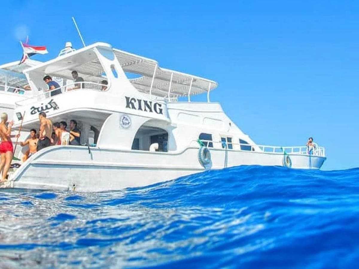 Day boat with an upper sun deck on deep blue water, one of the many excursions from Marsa Alam