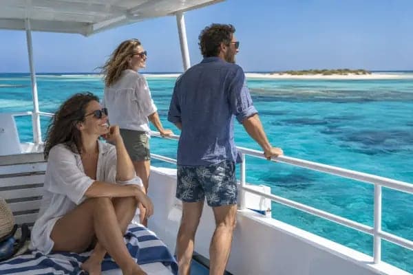 Hosté odpočívají na slunci na palubě lodi nad čistou tyrkysovou vodou u Marsa Alam